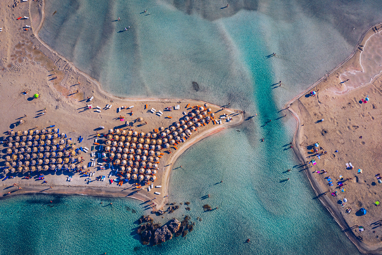 Aerial view of beautiful tropical Elafonissi Beach with pink san Aerial view of beautiful tropical Elafonissi Beach with pink sand. View of a nice tropical Elafonissi beach from the air. Beautiful sky, sea, resort. Elafonissi beach, Crete, Greece.